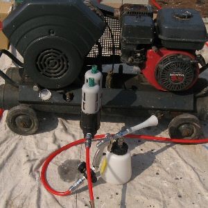 コンプレッサーに取り付けられた空気清浄機と手元圧力調整可能なエアースプレーガンの写真