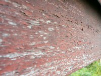 浮き塗膜の上に、下地処理を行わないで塗替えられた結果。3年ではがれた破風の表面。 浮き塗膜の上に、下地処理を行わないで塗替えられた結果。3年ではがれた破風の表面。